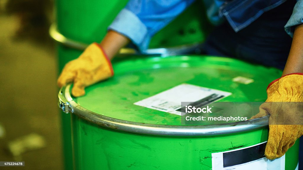 Human Hands In Protective Gloves Holding Oil Drum